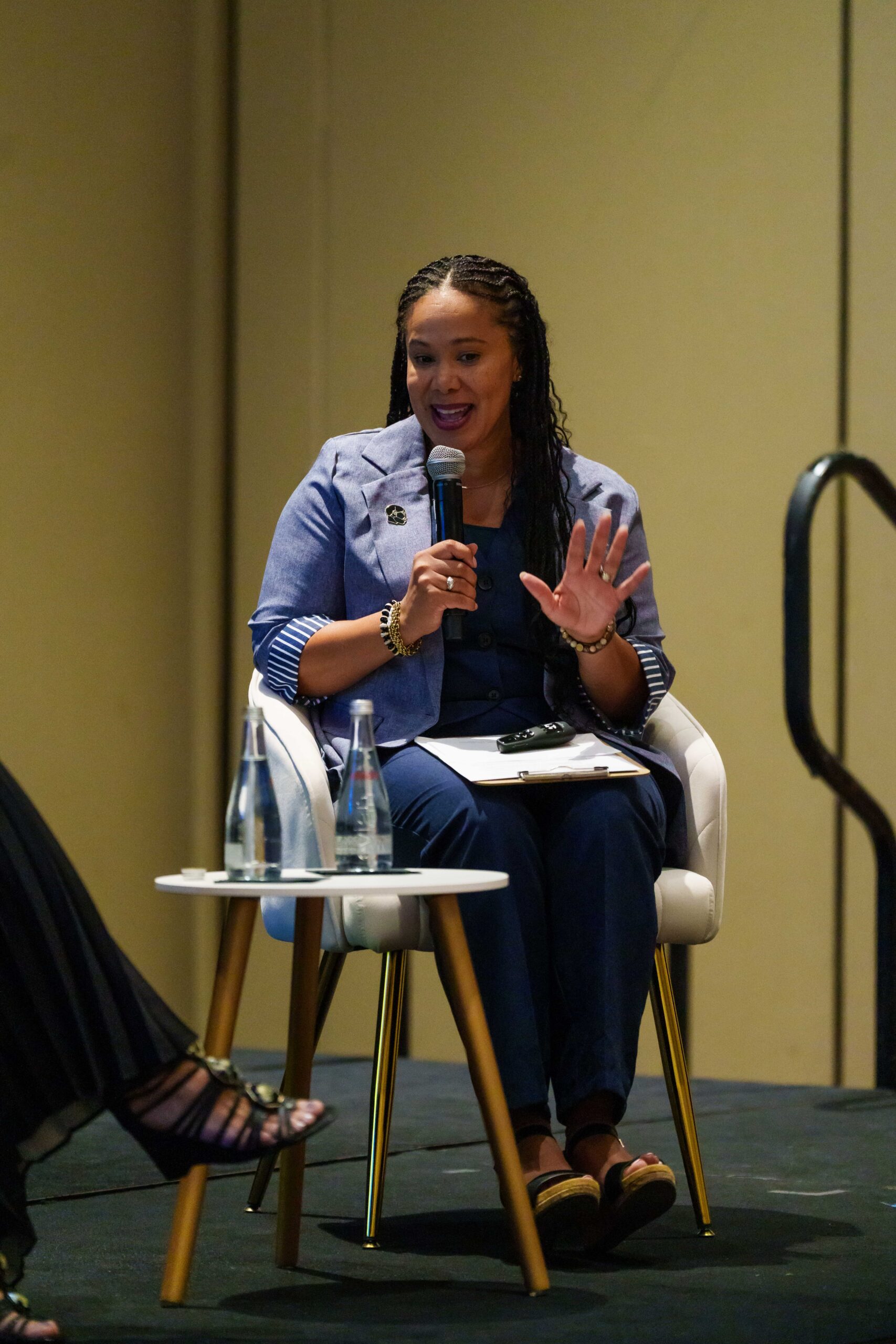 Kelli Williams speaking into a microphone during a fireside conversation